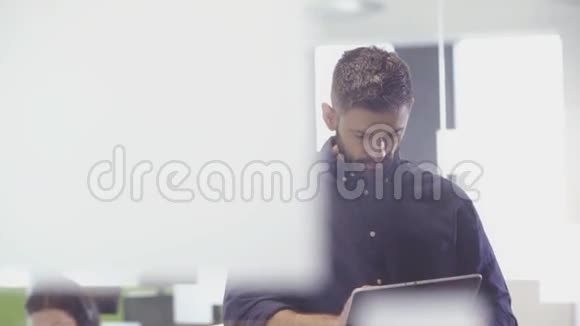 在办公室里使用平板电脑时商人微笑着拍照视频的预览图