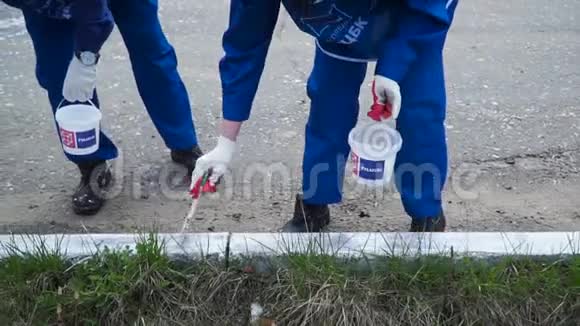 人们用手工作戴白色手套在边界上用油漆刷画画剪辑油漆的工人视频的预览图