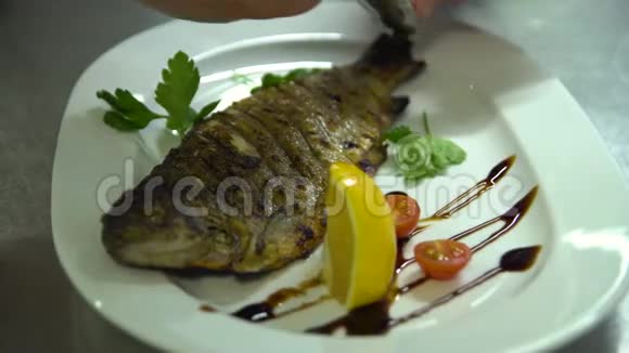 厨房餐厅做饭厨师把黑色鱼子酱放在鱼盘上视频的预览图