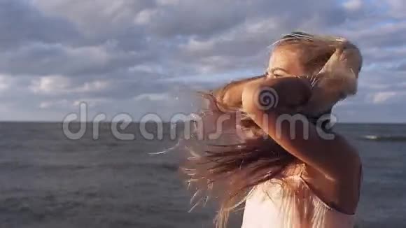女孩在海滩上对着镜头微笑视频的预览图