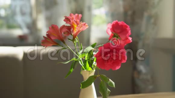 特写镜头在一个阳光明媚的夏日在咖啡馆里一束可爱的红玫瑰和放在桌上的花瓶里的自由女神视频的预览图