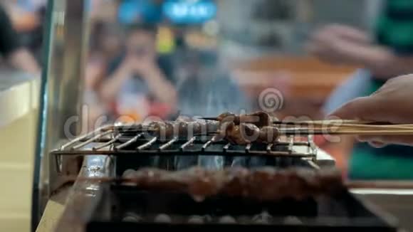 在木棍上的烤架中特写肉片亚洲美食视频的预览图