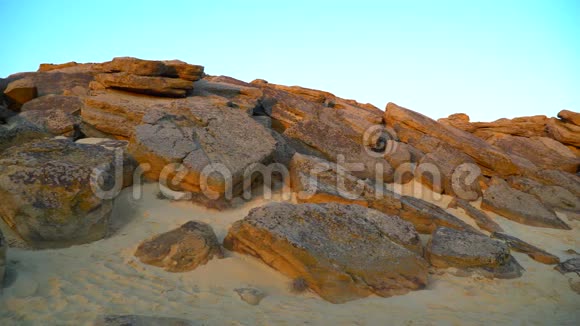 沙滩上的岩石碎片对抗蓝天视频的预览图