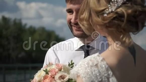 可爱的新婚夫妇站在码头上视频的预览图