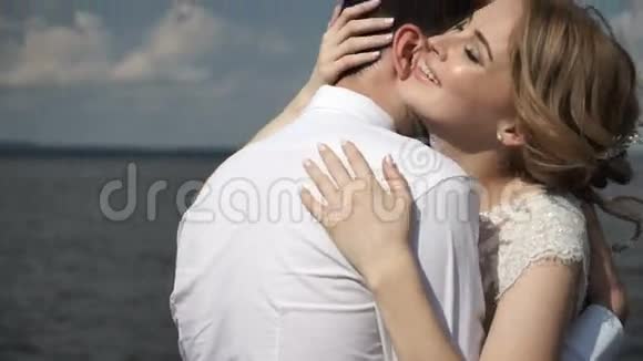 新郎新娘在码头上欢笑拥抱视频的预览图