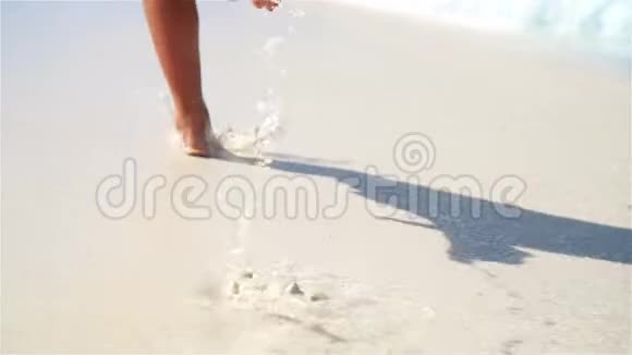 特写双腿在浅水中沿着白色海滩奔跑海滩度假和赤脚的概念动作缓慢视频的预览图