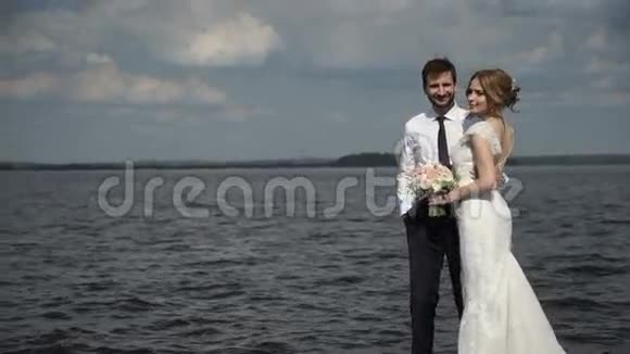 新娘和新郎在码头上为摄影师摆姿势视频的预览图