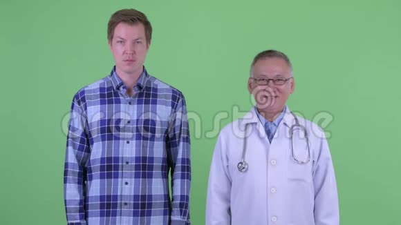 快乐成熟的日本男子医生和年轻男子一起微笑视频的预览图