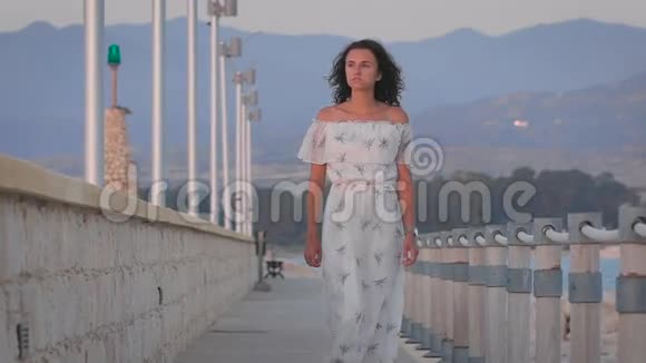 一个美丽浪漫悲伤的女人在港口散步视频的预览图