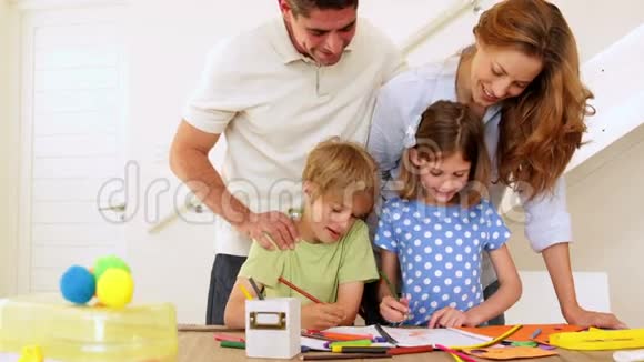 快乐的父母和孩子们一起在桌子旁看着摄像机视频的预览图