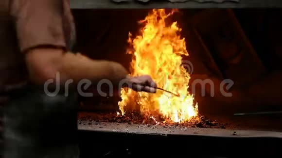 铁匠在火中加热金属棒视频的预览图