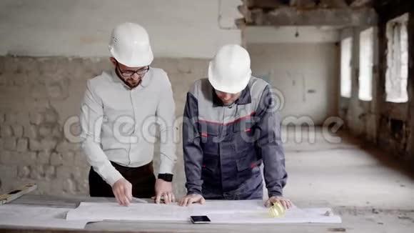主管和工人施工在工地背景下与建筑工人讨论工程计划视频的预览图