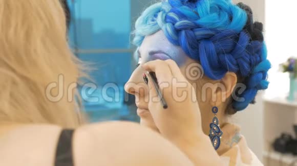 一位专业的化妆师在模特的眼皮上作画视频的预览图