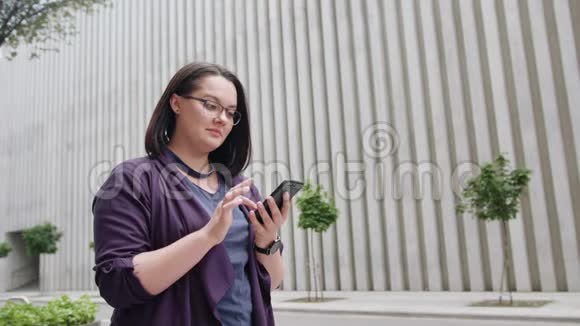 小镇上戴眼镜的年轻女士用电话视频的预览图