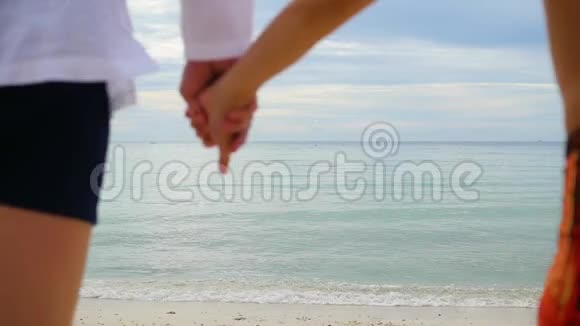 幸福的一家人牵着手沿着海岸奔跑在水里奔跑会产生飞溅视频的预览图