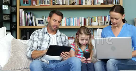 两个父母带着女儿使用技术视频的预览图