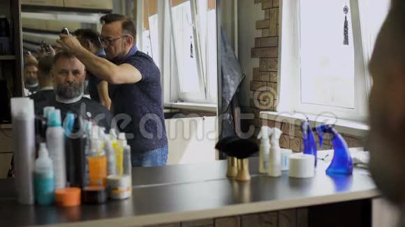 CzyBarbershop是一名职业发型师理发师年龄大一位可敬的商人坐在客户的椅子上视频的预览图