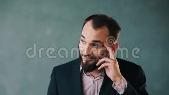 穿着夹克和条纹衬衫的胡子男人把手指放在太阳穴的隔离墙上视频的预览图