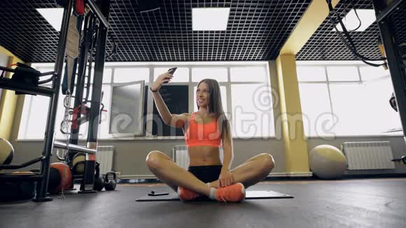 健身生活方式技术和人的概念有智能手机的年轻女性在健身房自拍视频的预览图
