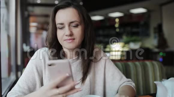 女人在咖啡馆里打电话喝拿铁视频的预览图