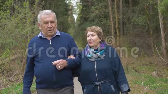 一对美丽的老夫妇走在公园里和蔼可亲地交谈着心情好生活积极视频的预览图