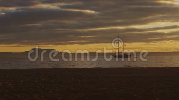 在海上美丽的夕阳下划出两桅游艇的轮廓视频的预览图