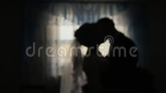 新娘和新郎的剪影在庆典前在黑暗中亲吻视频的预览图