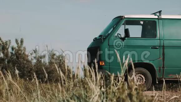 旧的生锈的绿色小货车停在肮脏的道路上干草视频的预览图