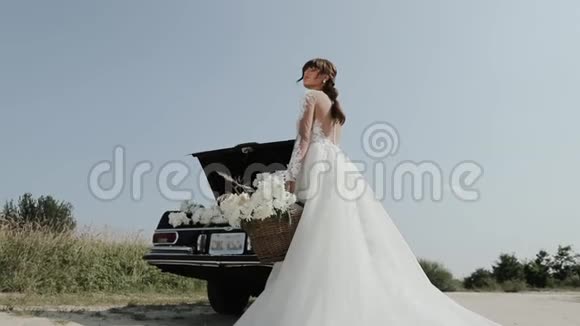 年轻美丽的女人穿着婚纱在古董车附近拍照视频的预览图