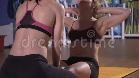 运动女人做腹肌锻炼要有平坦的腹部在健身俱乐部训练在健身房运动漂亮的女人这就是视频的预览图