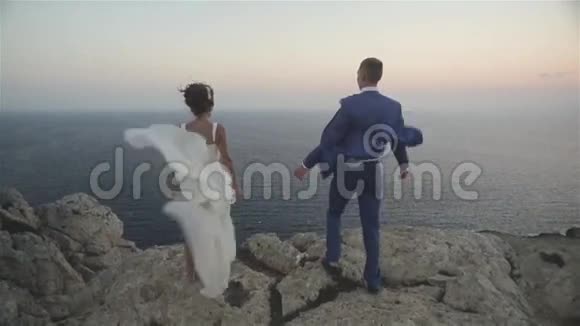 婚礼情侣站在海上悬崖上视频的预览图