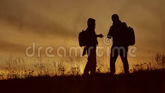 两名游客在夕阳的阳光下自拍旅行两个人夹克做自拍秋日剪影视频的预览图