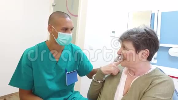 男牙科医生与微笑的老年妇女交谈视频的预览图