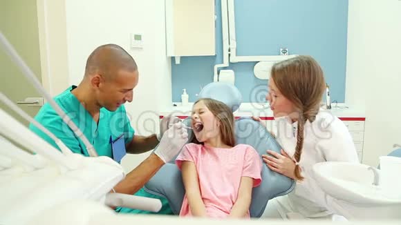 牙科助理和可爱的小女孩五岁后牙科检查视频的预览图