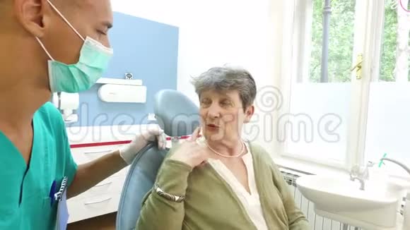 老年妇女向男性牙科医生呈牙痛状视频的预览图