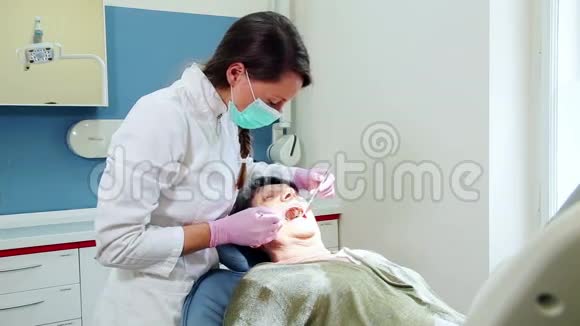 为年老病人做牙科治疗的女牙医视频的预览图