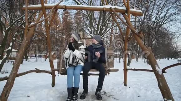 浪漫的情侣在冬季公园散步喝茶视频的预览图