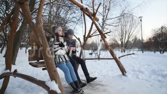 浪漫的情侣在冬季公园散步喝茶视频的预览图