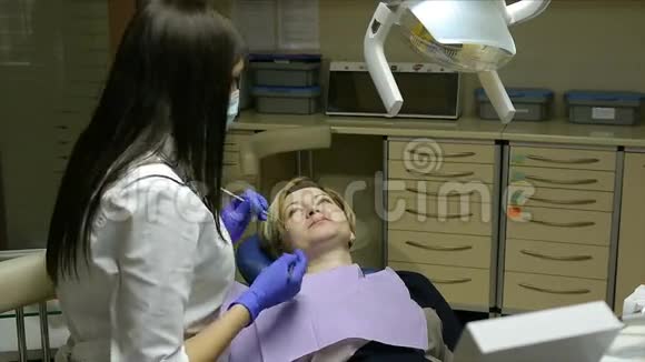 牙医检查和治疗他办公室里的女人视频的预览图