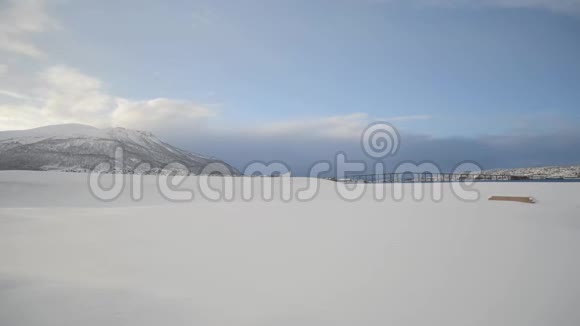 在特罗姆塞德伦和特罗姆塞城的岛屿上长而白色的雪域有着强大的山峰和日出的太阳视频的预览图