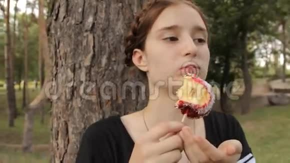 少女沉思地吃糖果苹果视频的预览图