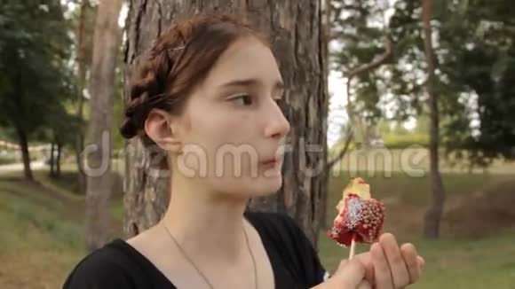 可爱的女孩吃糖果苹果放大和缩小视频的预览图