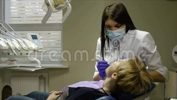 牙医检查和治疗他办公室里的女人视频的预览图