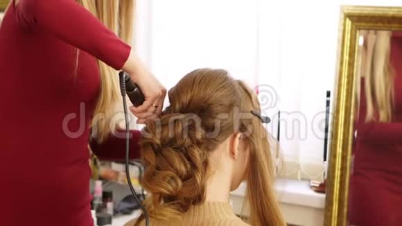 理发师给模特女孩的头发量这个女人做了一个漂亮的卷毛视频的预览图