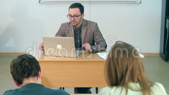 快乐的老师带着笔记本电脑上课视频的预览图