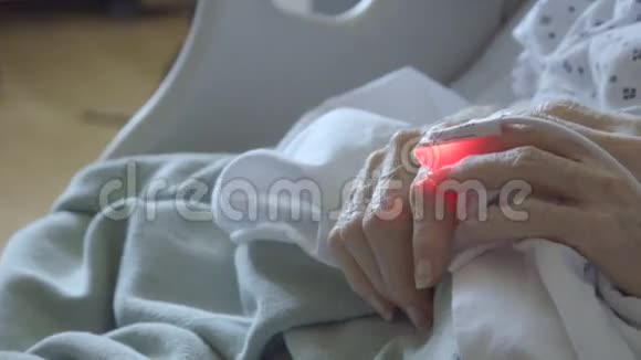 与老年妇女手指相连的心脏监视器细节视频的预览图