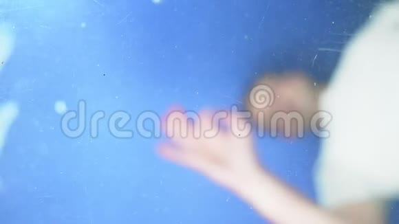 一个人把硬币扔进水里从水下看到的景色视频的预览图