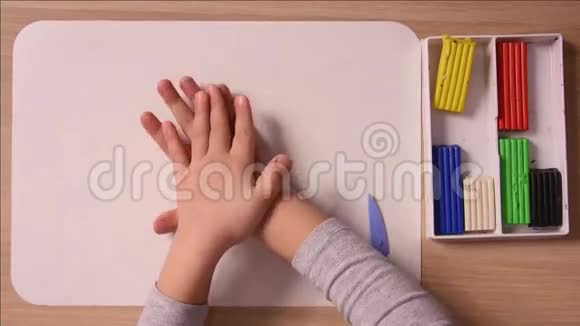 孩子伸出双手在黑板上放一块粘土用来做模特和特写视频的预览图