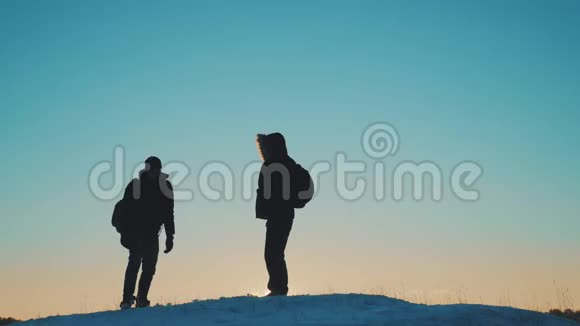 两个徒步旅行的游客走在日落山顶剪影团队合作旅游业务理念两个人视频的预览图