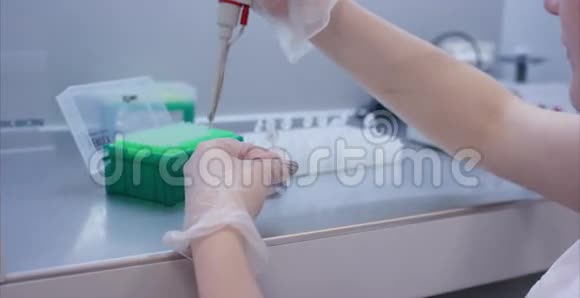 女医学家用吸管在实验室做研究研究概念戴着蓝色手套视频的预览图